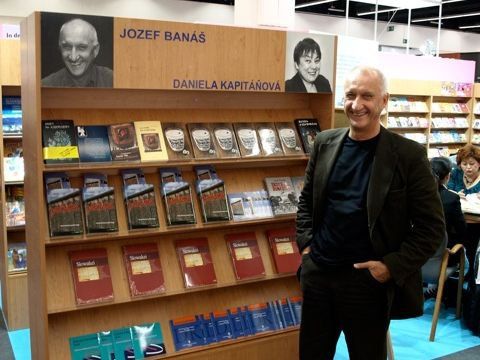 Jozef Banáš pri polici s knihami